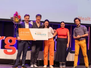 Een groepsfoto van de winnaars Nationale Zorginnovatie prijs 2023 met de cheque in handen